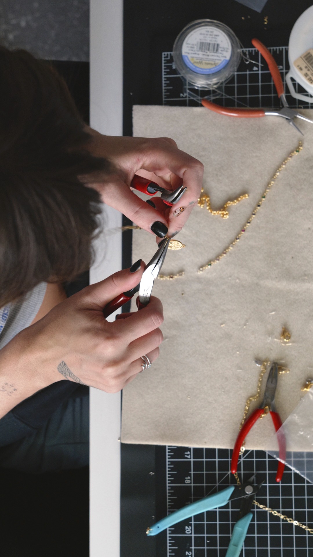 A jewelry maker assembling a gold necklace for The Hands That Made It