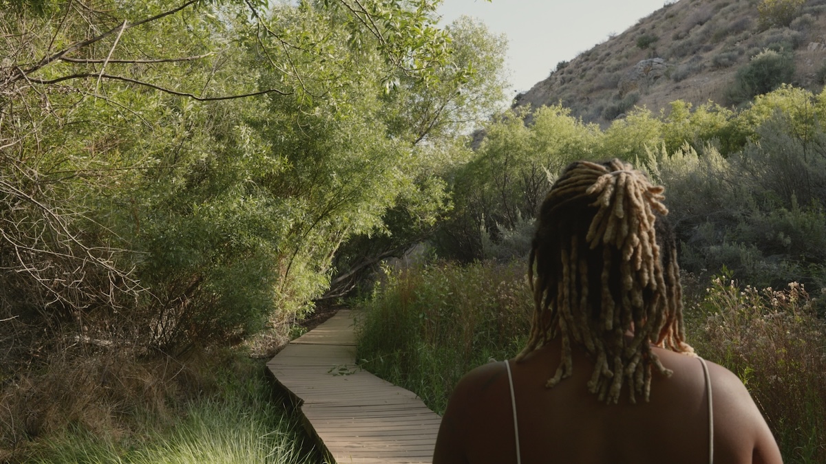 Jhaynane walking along a wooded trail during her recovery journey.
